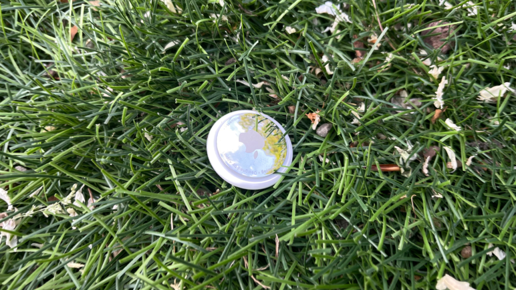 image d'un airtag posé dans l'herbe